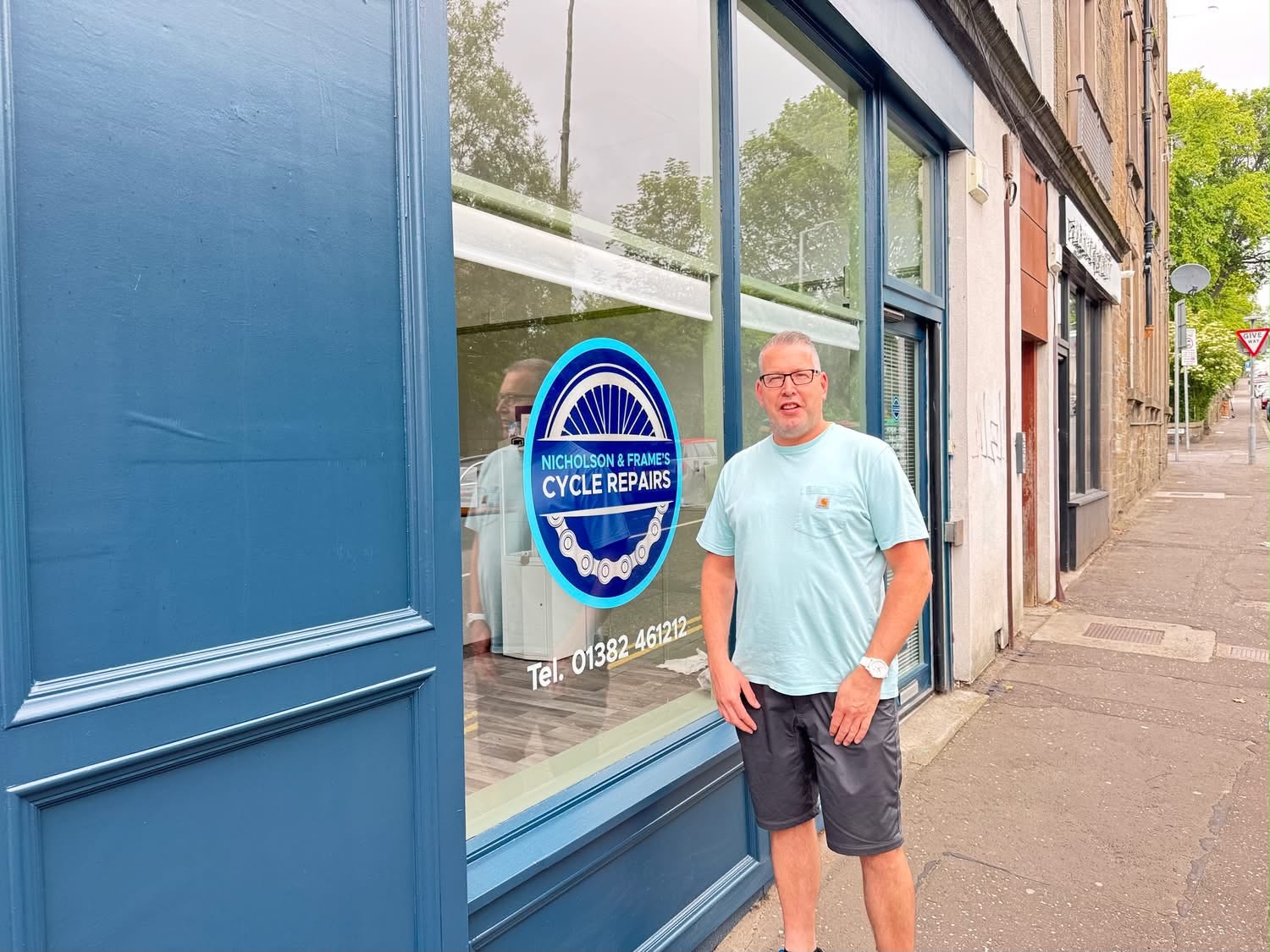 Billy outside the blue-fronted Nicholson & Frames cycle shop